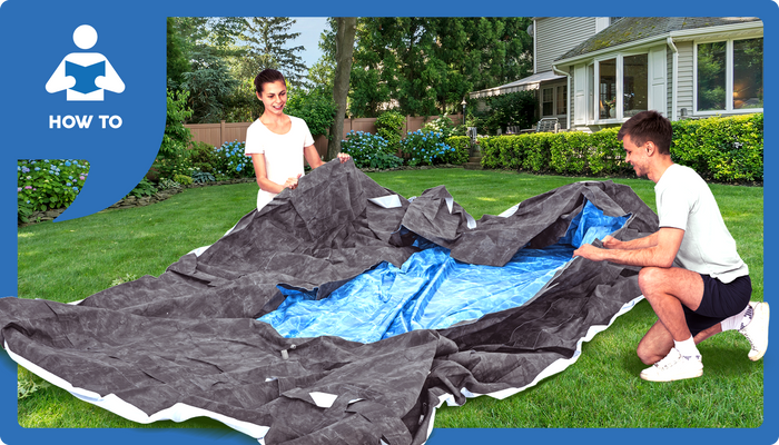 Two people taking down and folding an above ground pool on a grassy lawn.